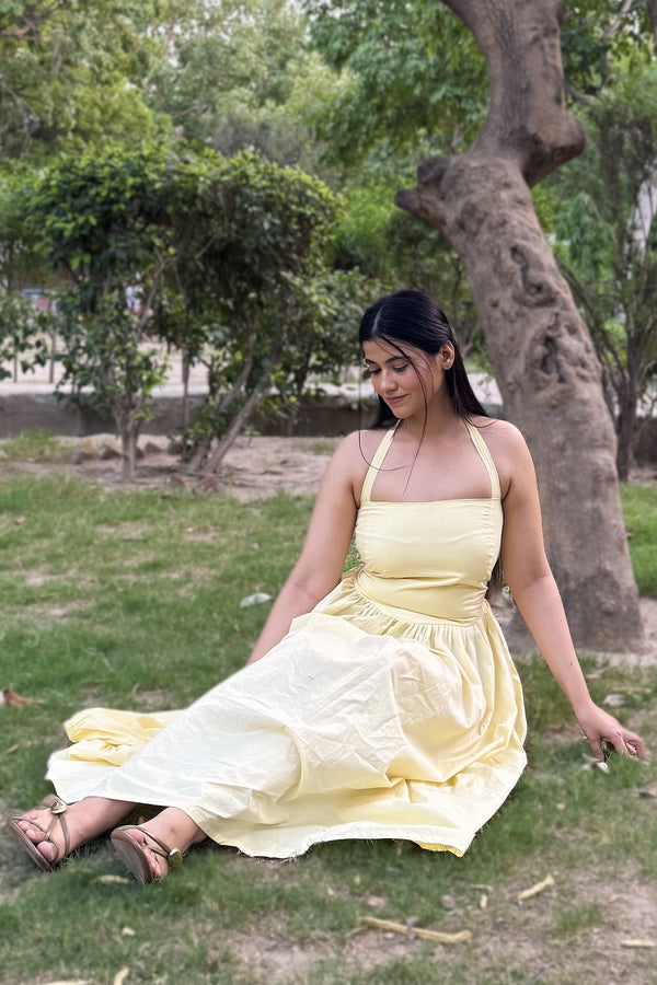 rooshy Butter Babe Corset Dress - model sitting on grass under tree in butter yellow halter corset dress