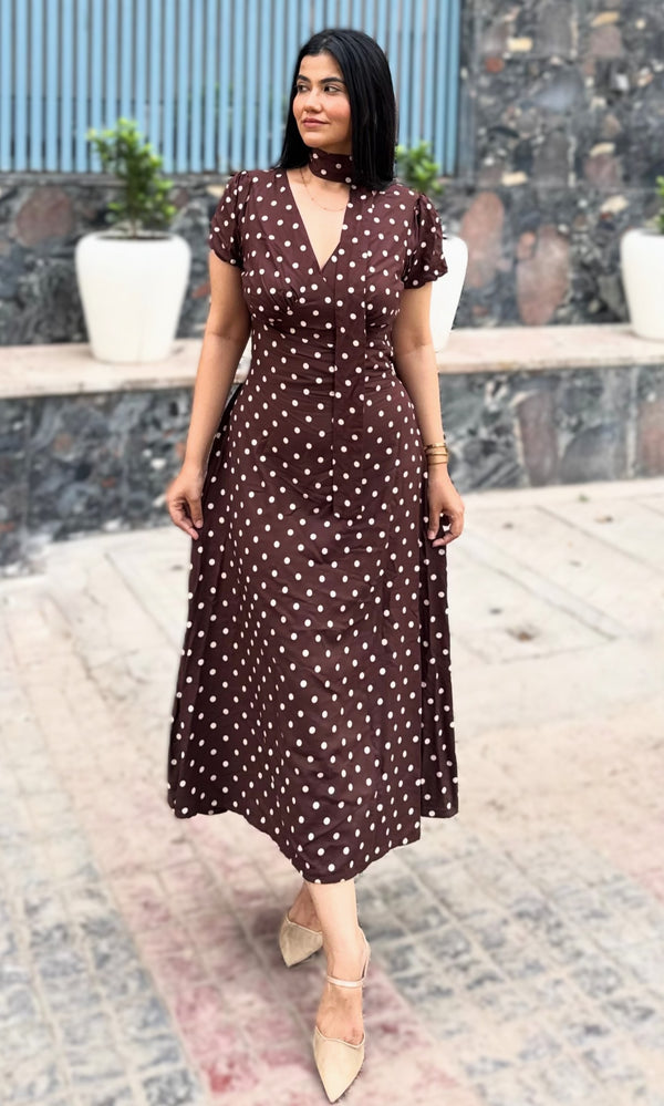 rooshy brown polka dot choker midi dress - model looking sideways full length in dark brown polka dot dress nude heels